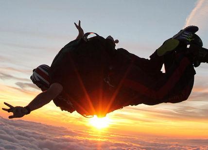 An image of a person flying in the sky, Tandem Skydive. Army Parachute Association