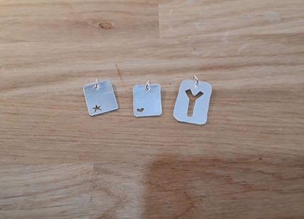 An image of a pair of earrings on a wooden table, Silver Charm Jewellery Making Class. Collette Dawn