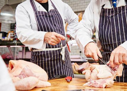 An image of two chefs preparing a chicken, Sausage Making Class. Hampstead Butcher