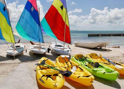 An image of a beach with kayaks and sailboats, Private Island Group Holiday on Little Whale Cay. Little Whale Cay