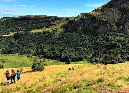 An image of people hiking in the mountains, Private Hike to the Top of Arthur’s Seat. Rishi's Edinburgh Tours