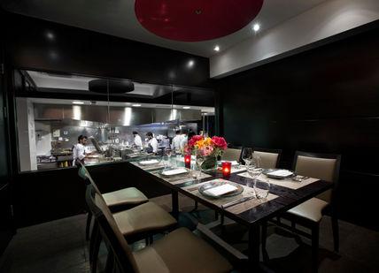 An image of a kitchen setting with a table and chairs, Benares Chef’s Table. Benares Restaurant and Bar