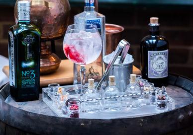 An image of a bar with alcohol and a bottle, The Gin & Tonic Experience. Chesterfield Mayfair Hotel