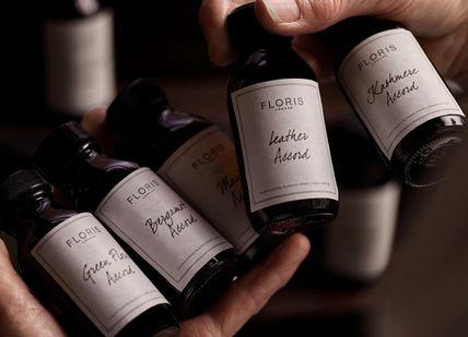 An image of a person holding a bottle of essential oils, Customise Your Own Fragrances. Floris
