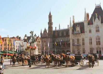 An image of a city street with horse drawn carriages, One-hour horse-drawn carriage ride (collection from the hotel and drop-off at the restaurant). Hippo Horse Drawn Carriages