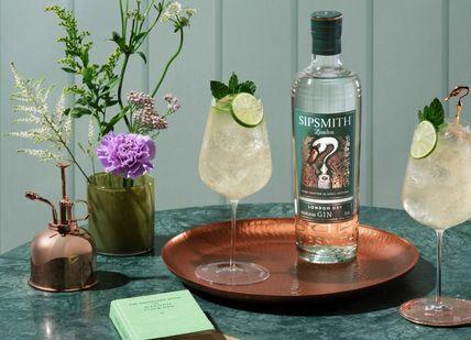 An image of a bottle of gin with a glass and a copper tray, Gin masterclass. Sipsmith Distillery
