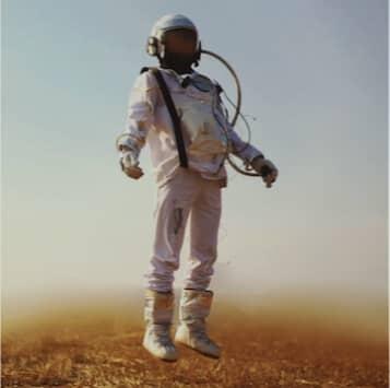 A man in a space suit standing in a field.