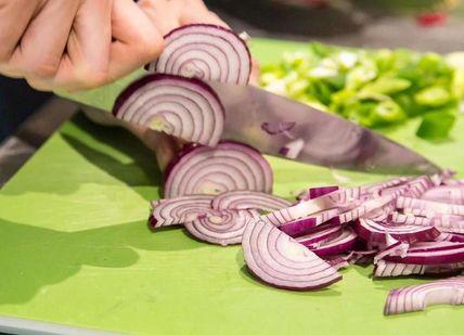 An image of person cutting onion