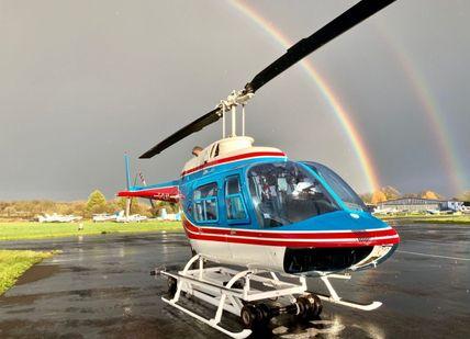 An image of B206 Jet Ranger and rainbow