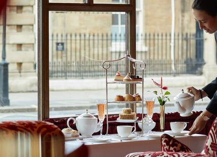 An image of a table with a tray of food, Royal Afternoon Tea. The Rubens at the Palace - The Palace Lounge
