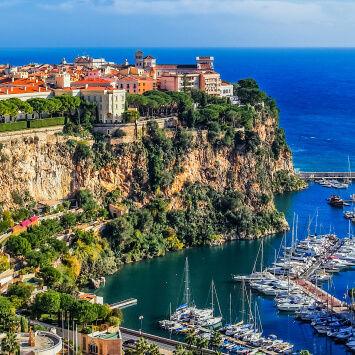The city of monaco on a cliff overlooking the ocean.