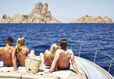 An image of two girls sitting on a boat, Private hire of a Pershing Yacht at Ibiza. 7Pines Kempinski Ibiza Resort