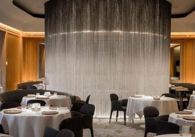 An image of a restaurant setting with a waterfall of water, Alain Ducasse at The Dorchester. Alain Ducasse at The Dorchester