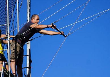 An image of a man on a high voltage power line, Open Flying. All Bars Flying Trapeze Club