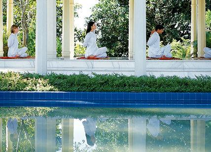 An image of a couple sitting on a bench by a pool, Personal Ayurvedic Programme. Ananda in the Himalayas