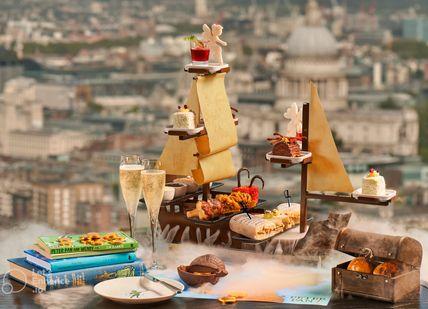 An image of a table with a boat and a lot of food, Champagne Afternoon Tea. Aqua Shard (The Shard)