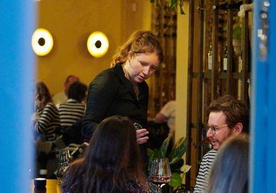 An image of a woman in a restaurant, Wine Tasting Flight. Aspen & Meursault