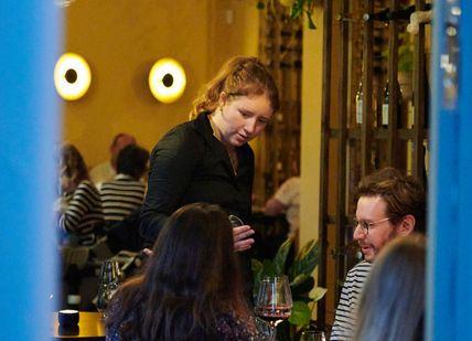 An image of a woman in a restaurant, Wine Tasting Flight. Aspen & Meursault