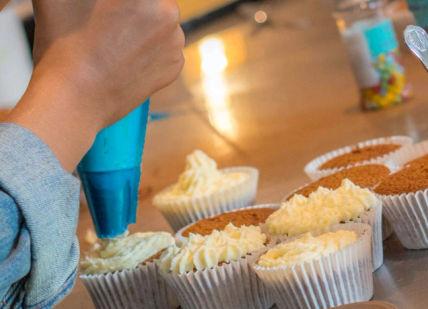 An image of a person eating a cupcake, Children’s Cooking Class. Avenue Cookery School