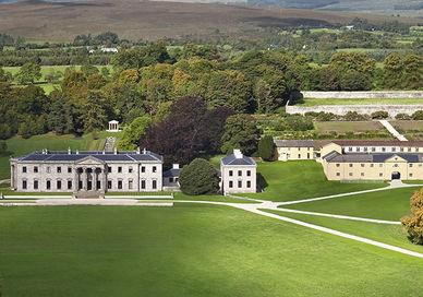 An image of a large white building in the middle of a green field, Escape to Ireland's Grandest Country House. Ballyfin