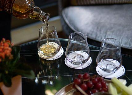 An image of a person pouring wine into glasses, Discover Whisky Masterclass. The Bar At The Athenaeum