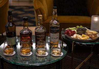 An image of a table with drinks and food, Essential Scottish Whisky Tasting. The Bar At The Athenaeum