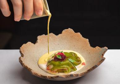An image of a person pouring a sauce on a dish, Tasting Menu. Benares Restaurant and Bar