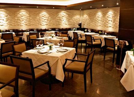 An image of a restaurant setting with tables and chairs, Three-course menu and champagne cocktail. Benares Restaurant and Bar