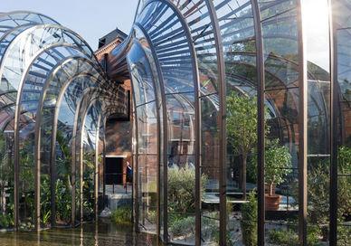 An image of a glass house with a pond in the middle of the house, Bombay Sapphire Distillery. Bombay Sapphire Distillery