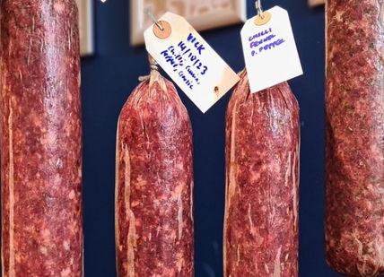 An image of some sausages hanging on a rack, Charcuterie Making Course. Bray Cured
