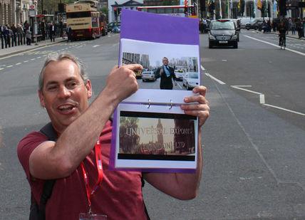 An image of a man holding a picture of a woman, Private James Bond Walking Tour of London. Brit Movie Tours