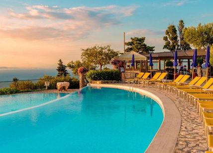 An image of a swimming pool with chairs and umbrellas, Stay, dinner, transfer, activity. Caesar Augustus Hotel