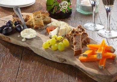 An image of a wooden board with food on it, Cheese Tasting Flight with Champagne for One glass of Michel Furdyna. Champagne + Fromage