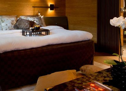 An image of a bedroom with a bed and a couch, Spa package. The Chedi Andermatt