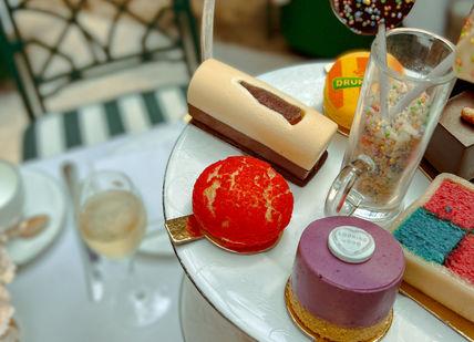An image of a table with a cake and desserts, Original Sweetshop Afternoon Tea. Chesterfield Mayfair Hotel
