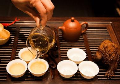 An image of a person pouring tea into cups, Gong Fu Tea Masterclass. The Chinese Tea Company