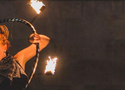 An image of a woman holding a fire, Private Circus Entertainment Masterclass. Circus Stardust