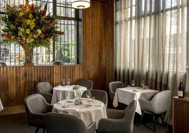 An image of a restaurant with tables and chairs, Club Gascon. Club Gascon