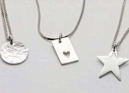 silver necklaces on a wooden table, Silver Charm Jewellery Making Class. Collette Dawn