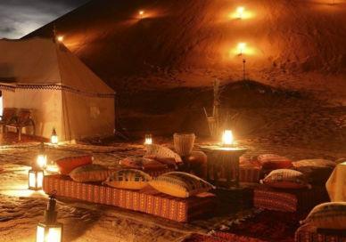 An image of a desert setting with candles, Moroccan Luxury Desert Camp Stay With Helicopter Transfer And Camel Trek. Desert Luxury Camp Morocco