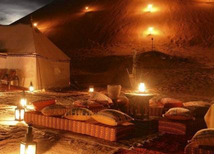 An image of a desert setting with candles, Moroccan Luxury Desert Camp Stay With Helicopter Transfer And Camel Trek. Desert Luxury Camp Morocco