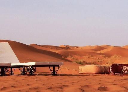 An image of a desert with two chairs and a table, Moroccan Luxury Desert Camp Stay With Helicopter Transfer And Camel Trek. Desert Luxury Camp Morocco