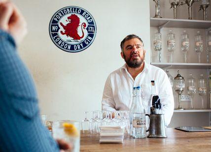 An image of a man sitting at a bar, The Ginstitute Experience. The Distillery