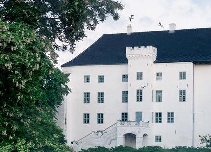 An image of a white house with trees in the background, Ghost Tour and Stay. Dragsholm Castle