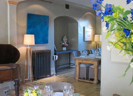 An image of a living room with a piano and flowers, Four-Course Dinner. The Dysart Petersham