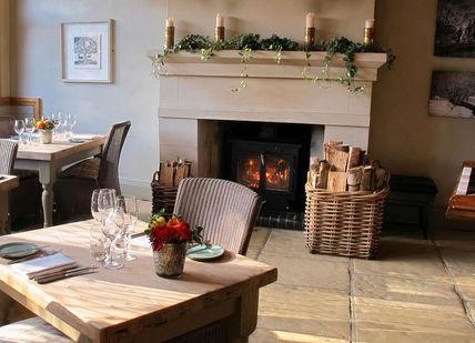 An image of a restaurant setting with a fire place, The Dysart Petersham. The Dysart Petersham