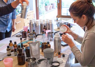 An image of a woman sitting at a table, Private Luxury Vegan Candle Making Workshop. Fais HQ
