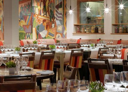 An image of a restaurant with colorful paintings, The Soho Hotel. Firmdale Hotels
