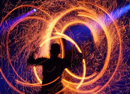 An image of a person with fire in the air, Private Fire Spectacle Workshop. Flame Oz