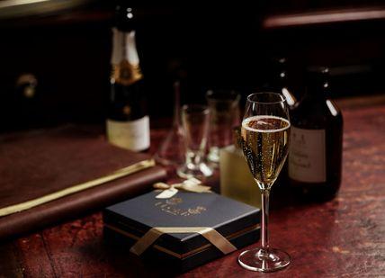 An image of a wine glass and a book, Create Your Own Fully-Bespoke Perfume. Floris